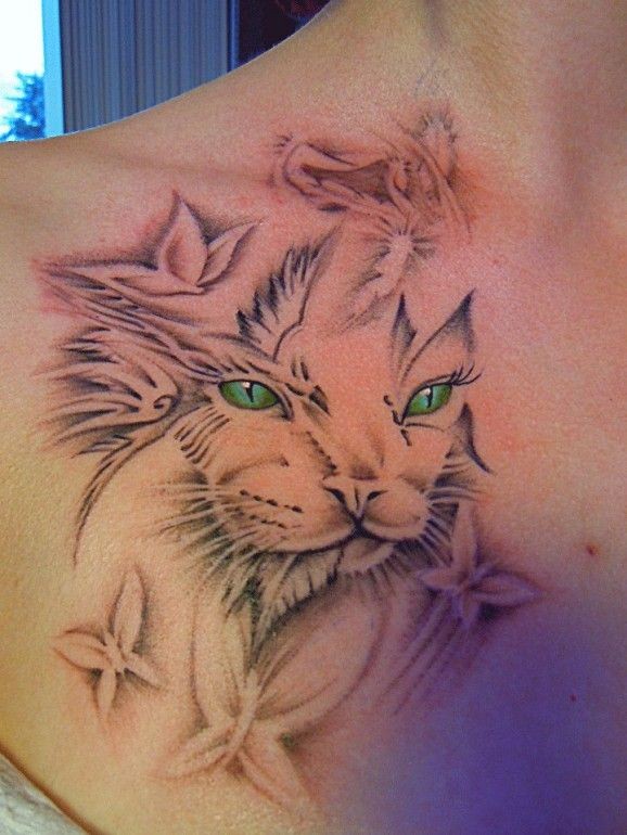 Black and gray cat tattoo with vibrant green eyes