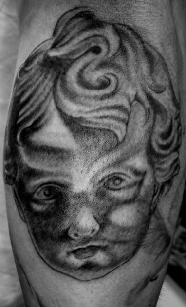 Black and gray cherub face tattoo