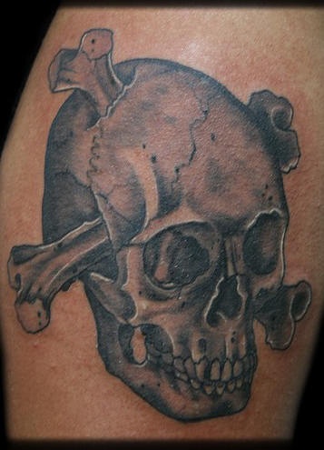 Le tatouage de crâne avec des os en noir et gris