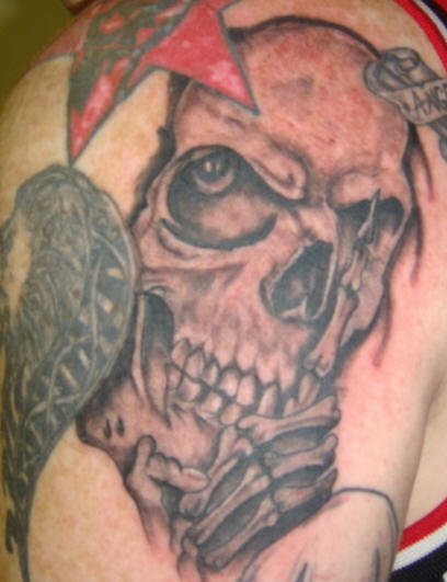 Black and gray skull with star tattoo