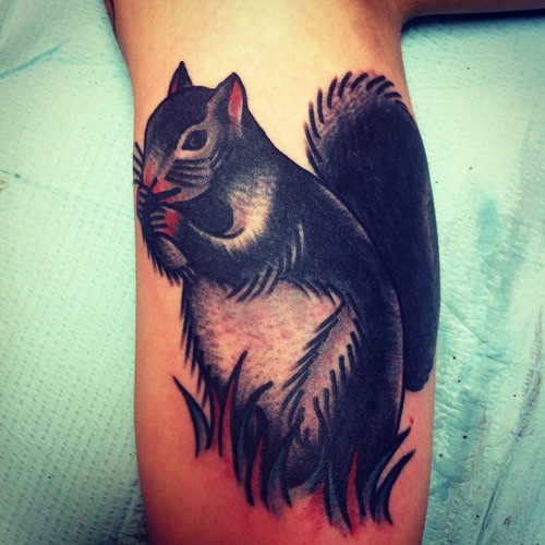 Black and gray squirrel tattoo on arm