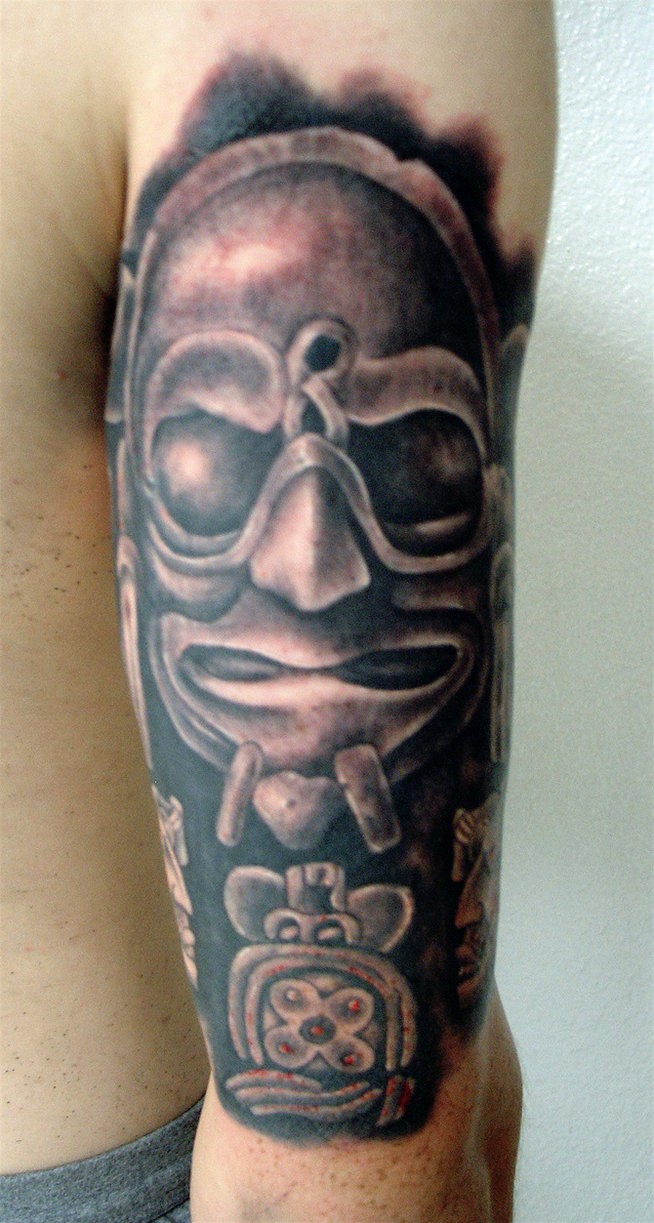 Black and gray style arm tattoo of stone statue