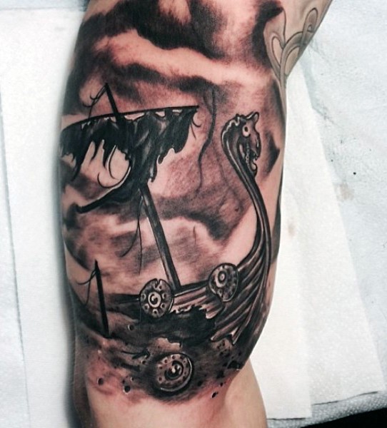 Black and gray style biceps tattoo of corrupted viking ship