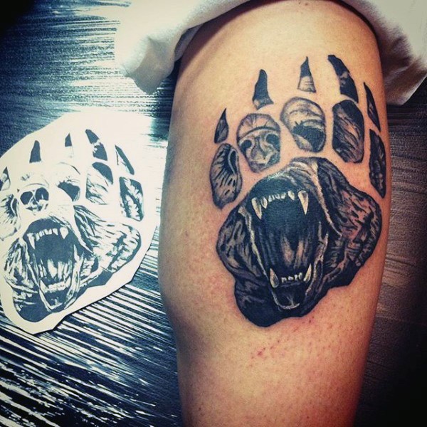 Black and gray style big animal paw shaped leg tattoo stylized with bear face