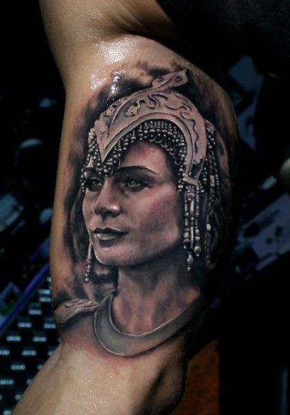 Black and gray style colored biceps tattoo of Egypt queen face