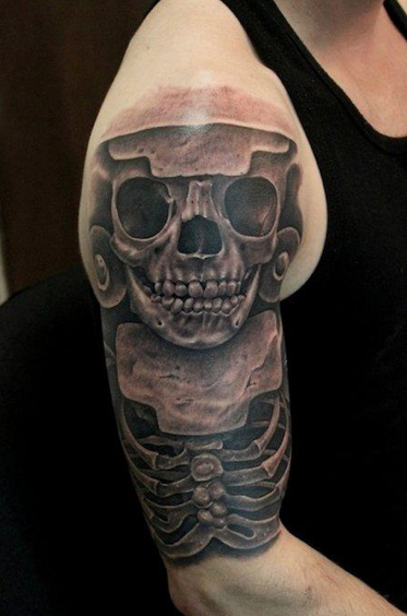 Black and gray style colored shoulder tattoo of ancient skeleton