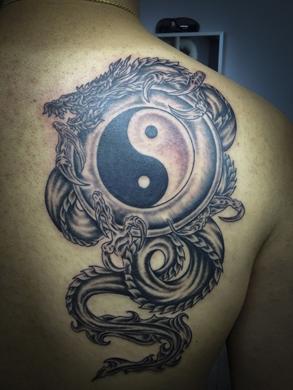 Black and gray style colored shoulder tattoo of Yin Yang symbol with dragon