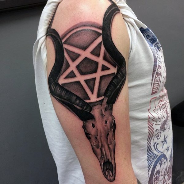 Black and gray style colored shoulder tattoo of demonic skull with devils star