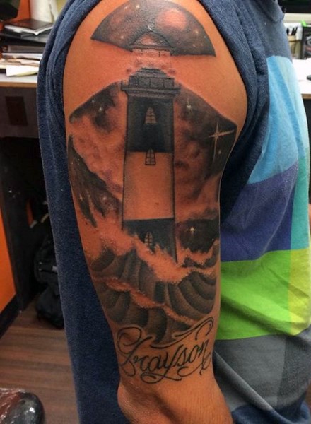 Black and gray style colored shoulder tattoo of night lighthouse and lettering
