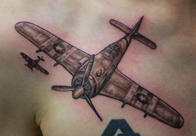 Black and gray style detailed chest tattoo of military plane