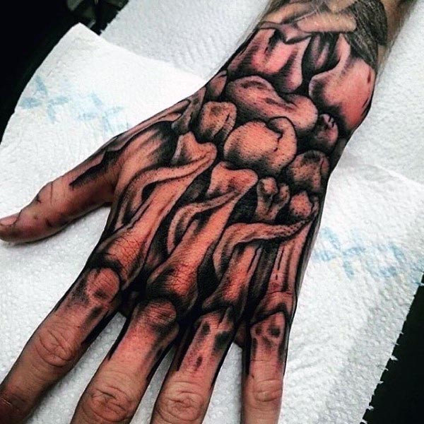 Schwarzes und graues detailliertes menschliches Knochen Tattoo am Handgelenk und Hand