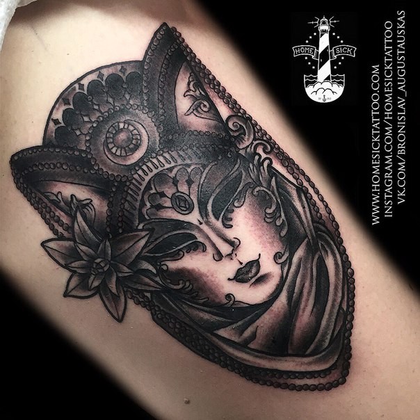 Black and gray style detailed looking arm tattoo of mystical mask with flower and ornaments