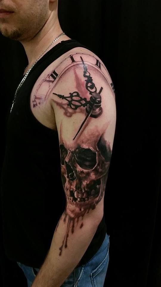 Black and gray style detailed shoulder tattoo of human skull and clock