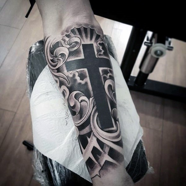 Black and gray style mystic cross in clouds tattoo on forearm