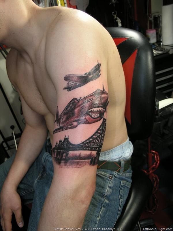 Black and gray style original looking shoulder tattoo of WW2 planes with bridge