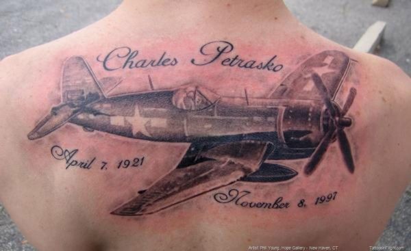 Black and gray style realistic looking upper back tattoo of amazing plane with lettering