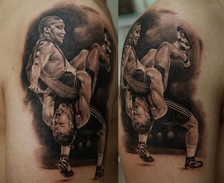 Black and gray style shoulder tattoo of wrestlers fight