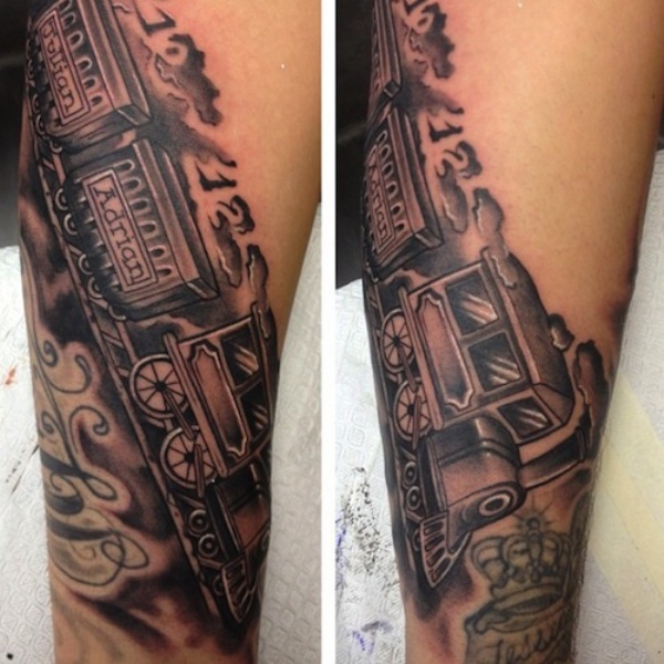 Black and gray style train with lettering tattoo on arm