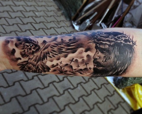Black and gray style unusual dramatic Jesus portrait tattoo on arm combined with cemetery and crow