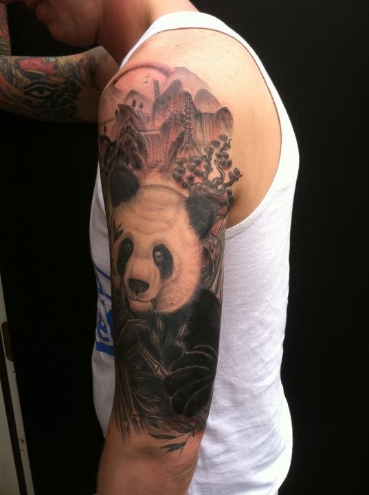 Black and gray style very detailed shoulder tattoo of panda bear in jungle