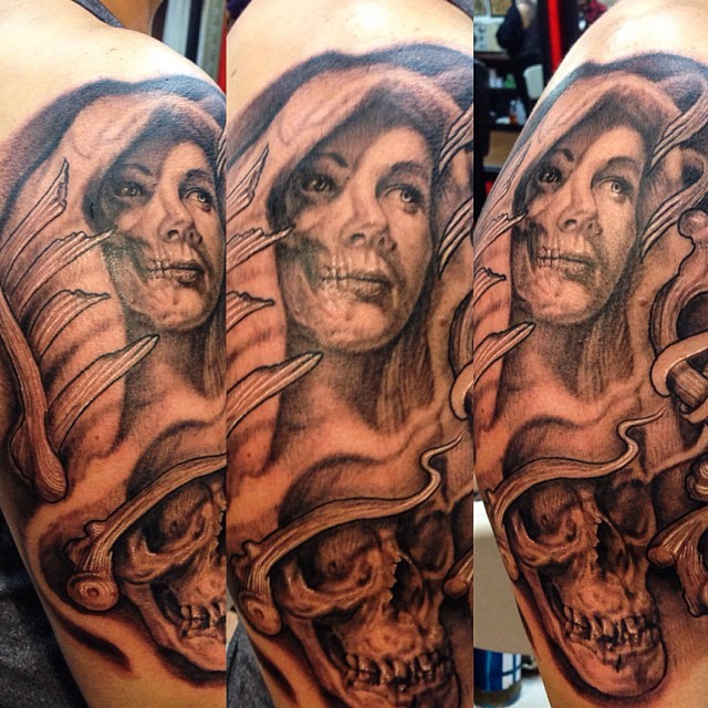 Black and gray style woman with skull tattoo on shoulder