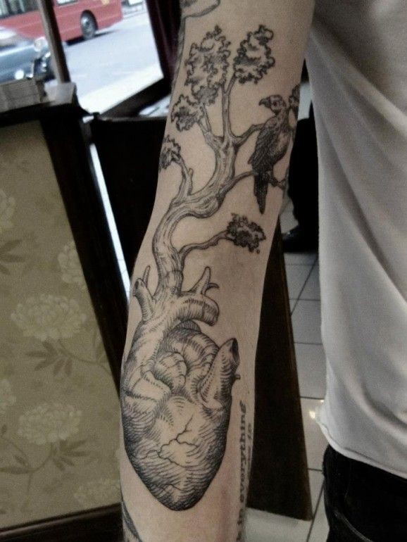 Tatuaggio grande sul braccio l&quotalbero con la radice nel cuore umano& l&quotuccellino