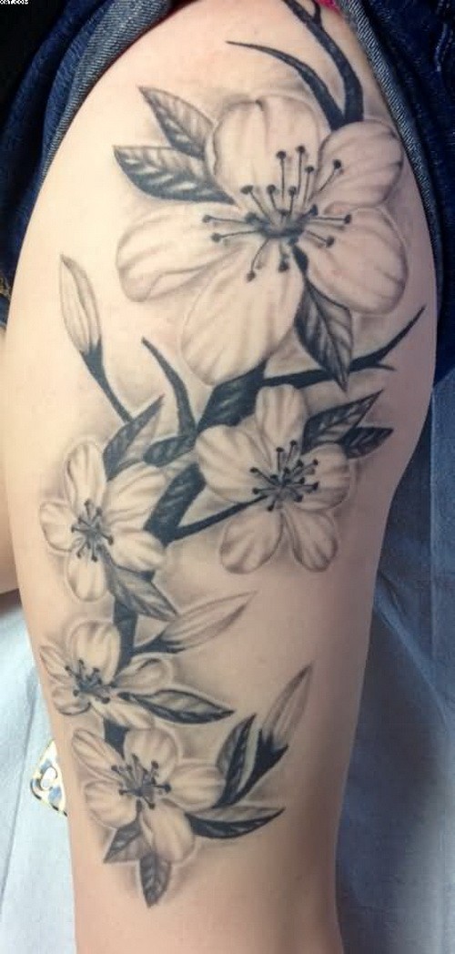 Black-and-gray vine flowers tattoo on thigh