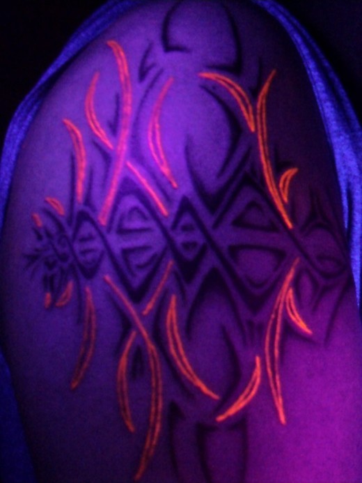 Black and red patterns light tattoo on shoulder
