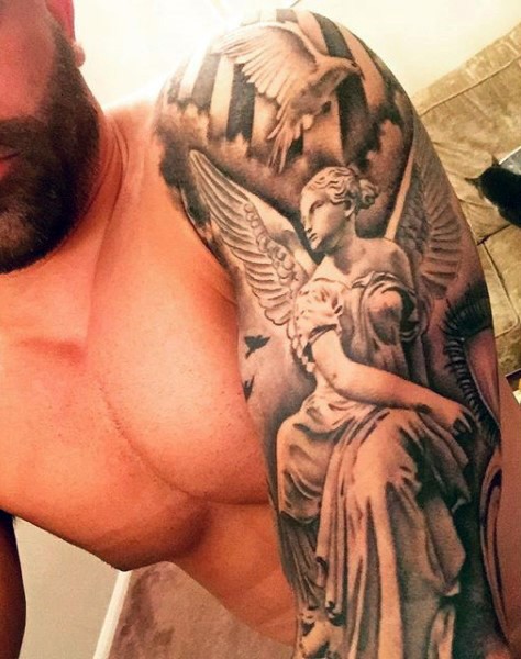 Black and white antic angel statue tattoo on shoulder with flying pigeons