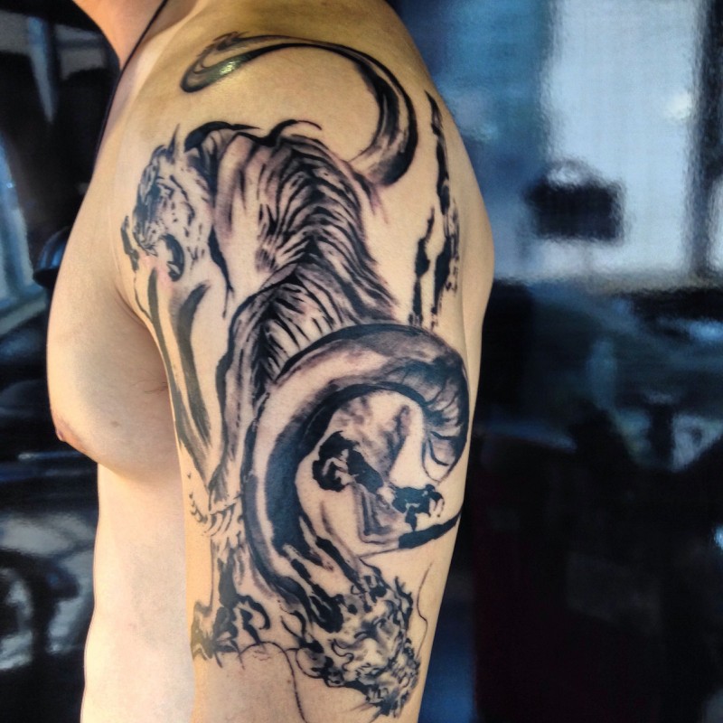 Schwarzweißes nett aussehendes Tiger Tattoo an der Schulter mit großer Schlange