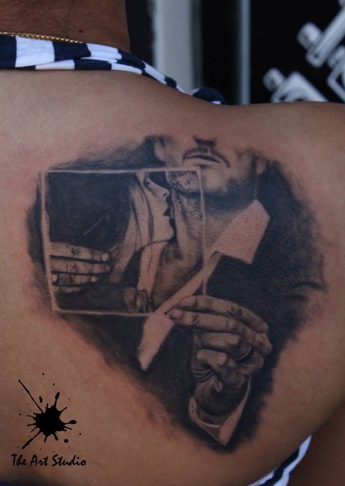 Black and white scapular tattoo of man and woman portrait