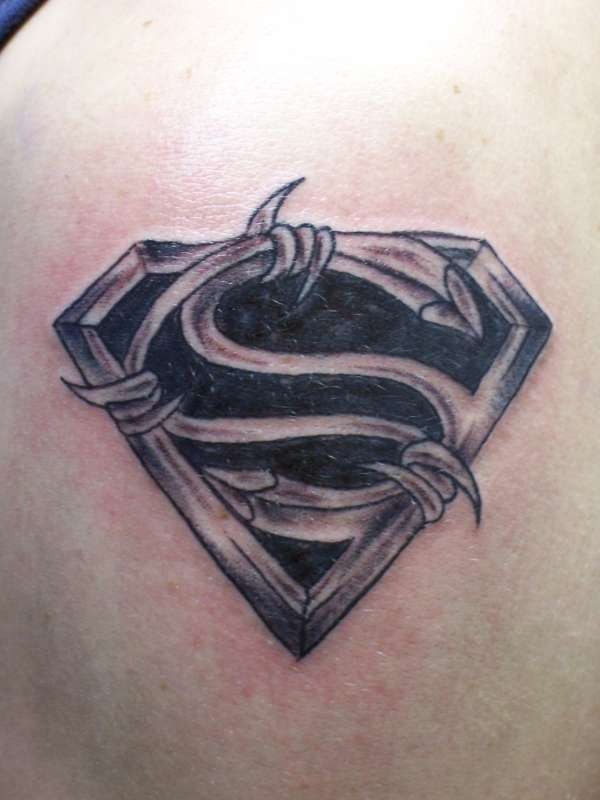 Black and white Superman&quots emblem stylized with bribed wire tattoo on shoulder