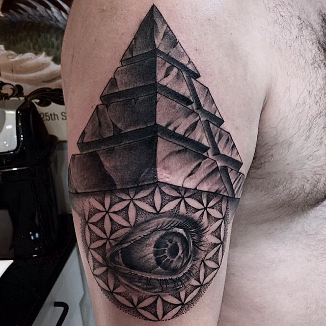 Black and white tribal pyramid tattoo on shoulder combined with mystic eye