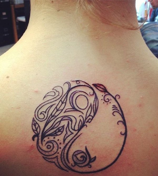Black and white Yin Yang symbol back tattoo stylized with fish ornament