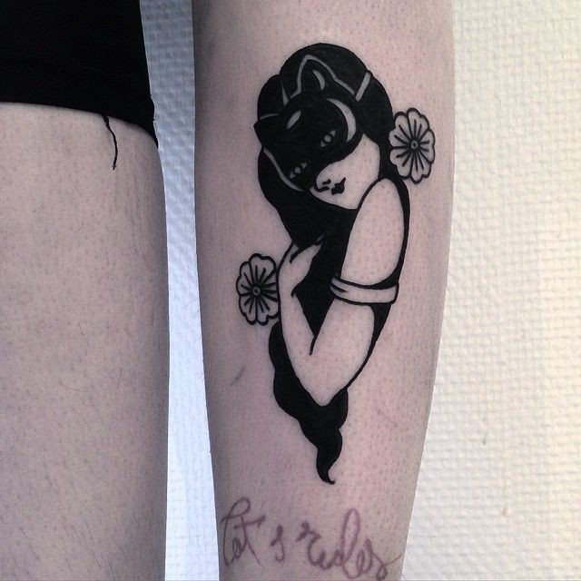Black arm tattoo of woman with mask and flowers