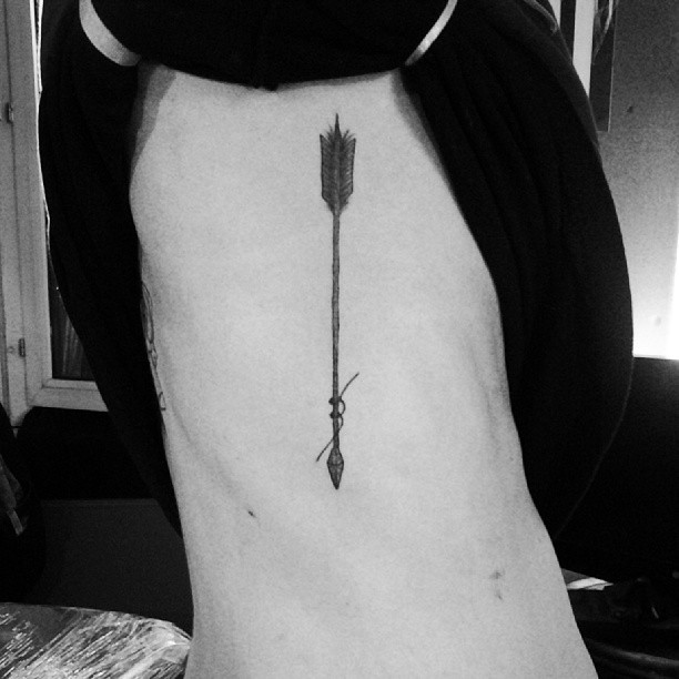 Black arrow tattoo on ribs