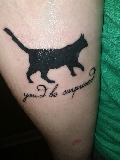 Tatuaje en el brazo, gato negro, inscripción