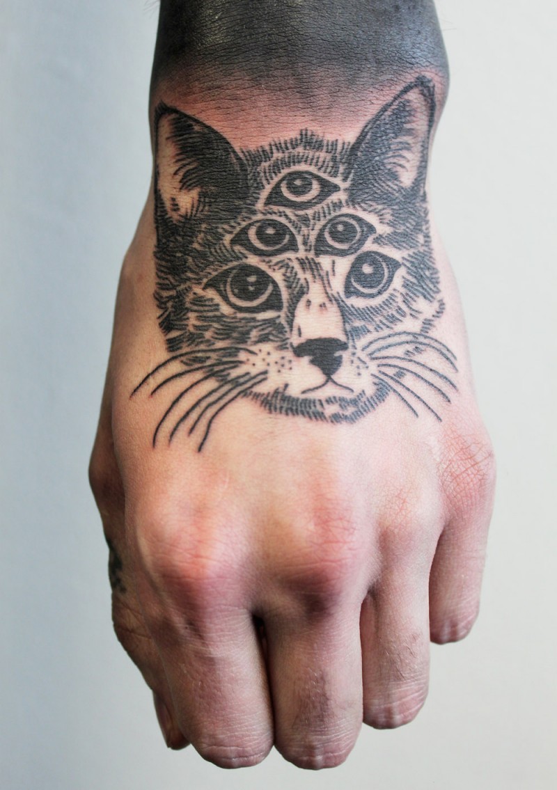 Tatuaje en la mano,  gato surrealista con cinco ojos