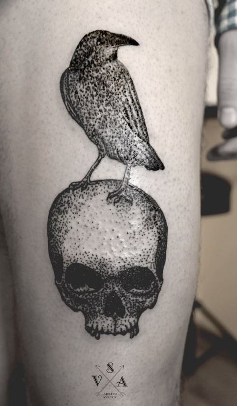 Tatuaje en el muslo,  cuervo en el cráneo humano, tinta negra