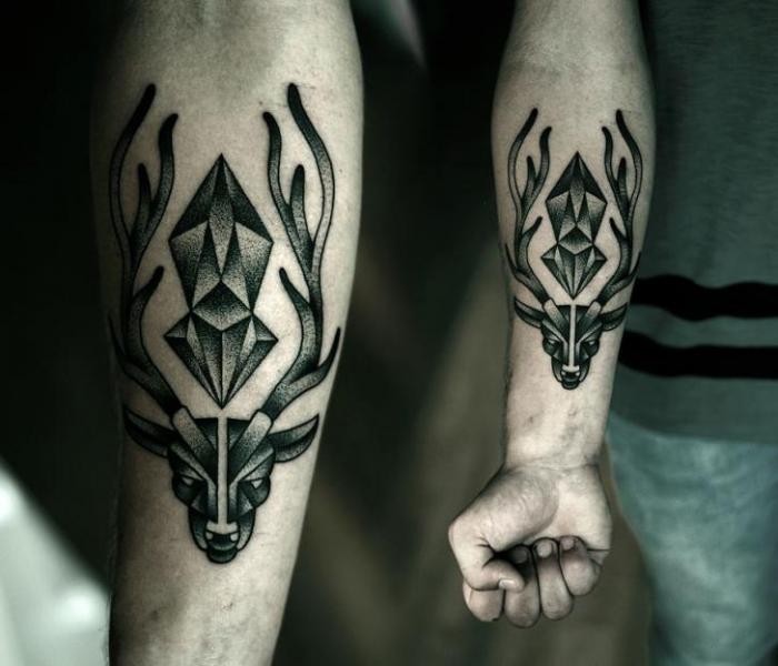 Tattoo von schwarzem Hirsch mit Dieamant im Dotwor Stil am Unterarm