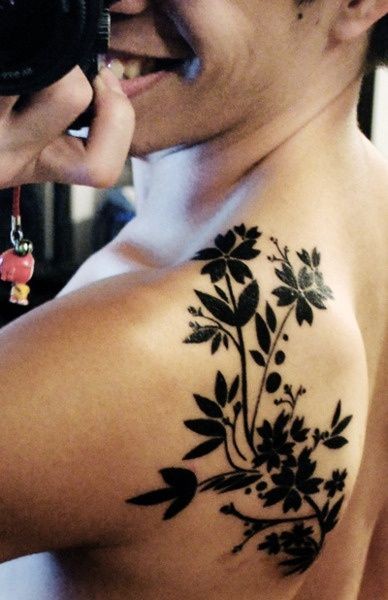 Black flowers tattoo on shoulder blade