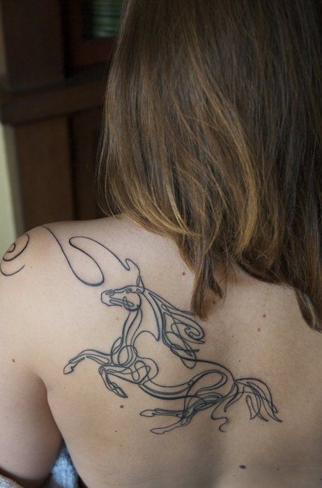 Black horse silhouette tattoo on shoulder blade