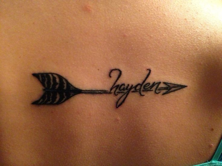 Tatuaje  de flecha con nombre en la espalda