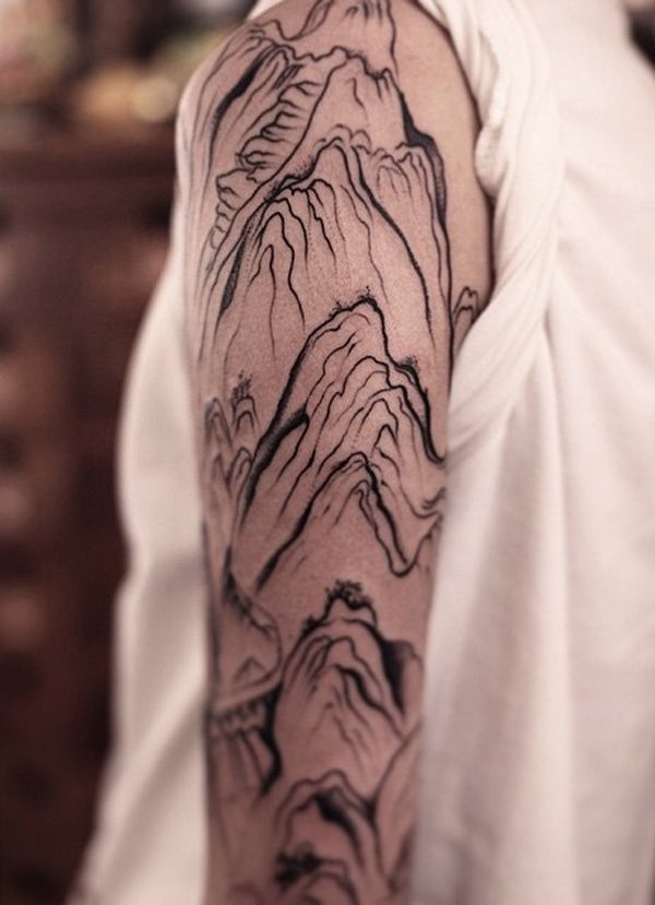 Black ink abstract style shoulder tattoo of mountains