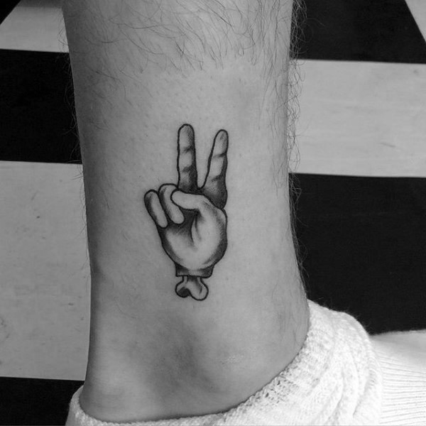 Black ink ankle tattoo of human hand