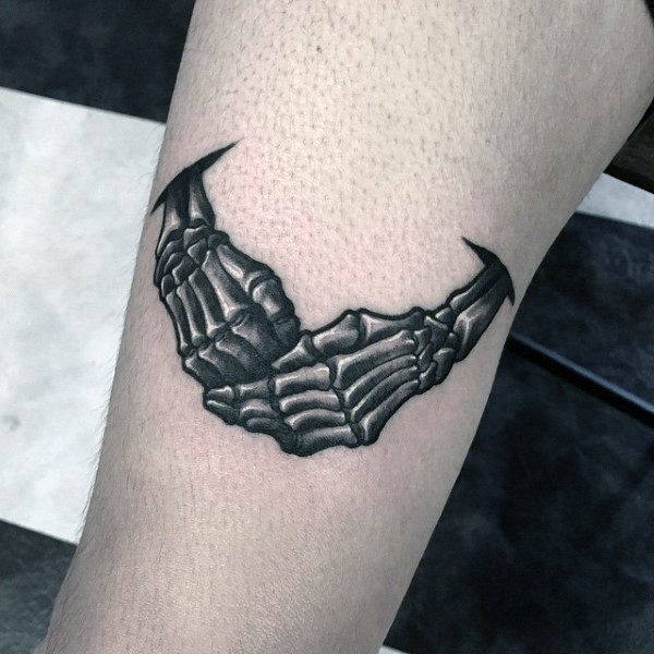 Black ink arm tattoo of skeleton hands