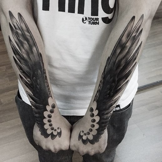 Black ink arms tattoo of fantasy wings