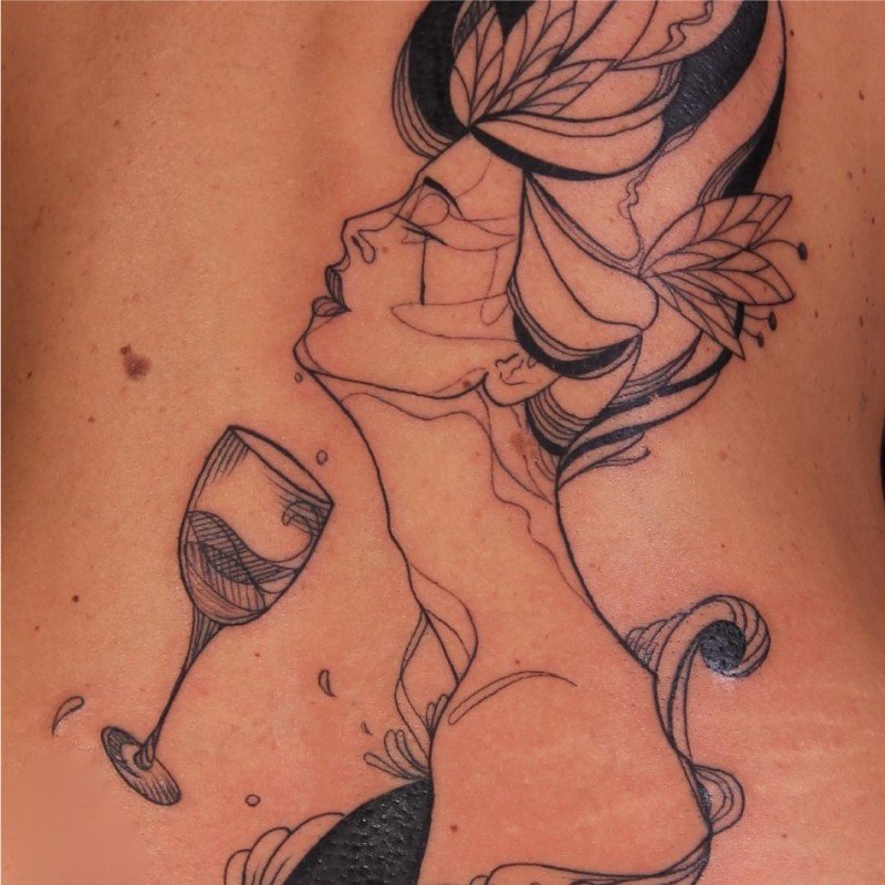Black ink back tattoo of woman with flower and glass