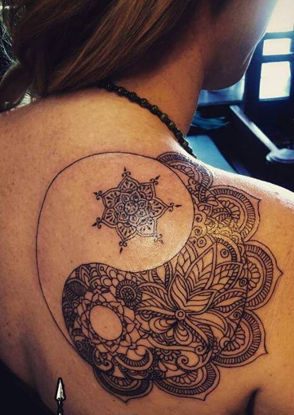 Black ink back tattoo of Yin Yang symbol stylized with various ornaments