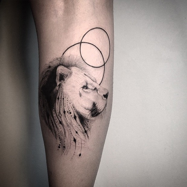 Black ink beautiful looking leg tattoo of lion head with circles